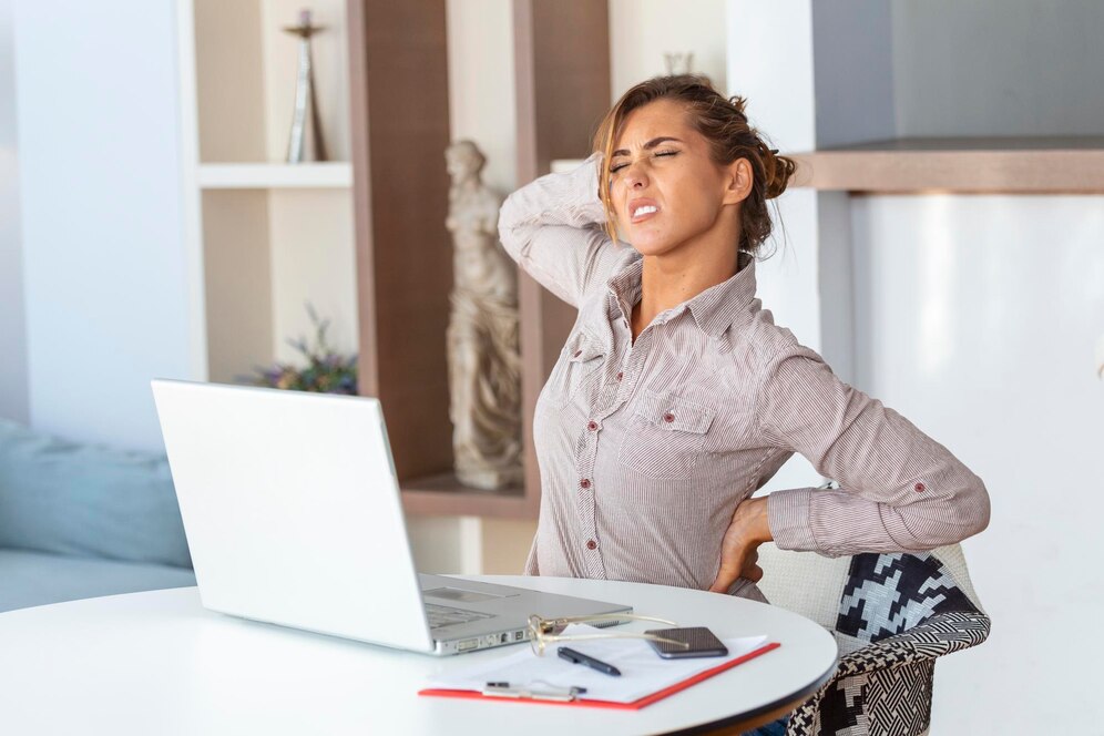 portrait-young-stressed-woman-sitting-home-office-desk-front-laptop-touching-aching-back-with-pained-expression-suffering-from-backache-after-working-laptop_657921-444
